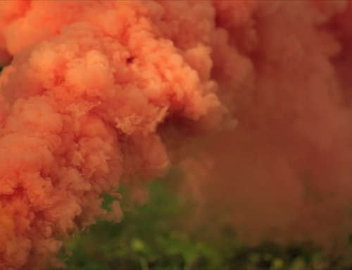Orange grenade smoke video footage in slow motion.